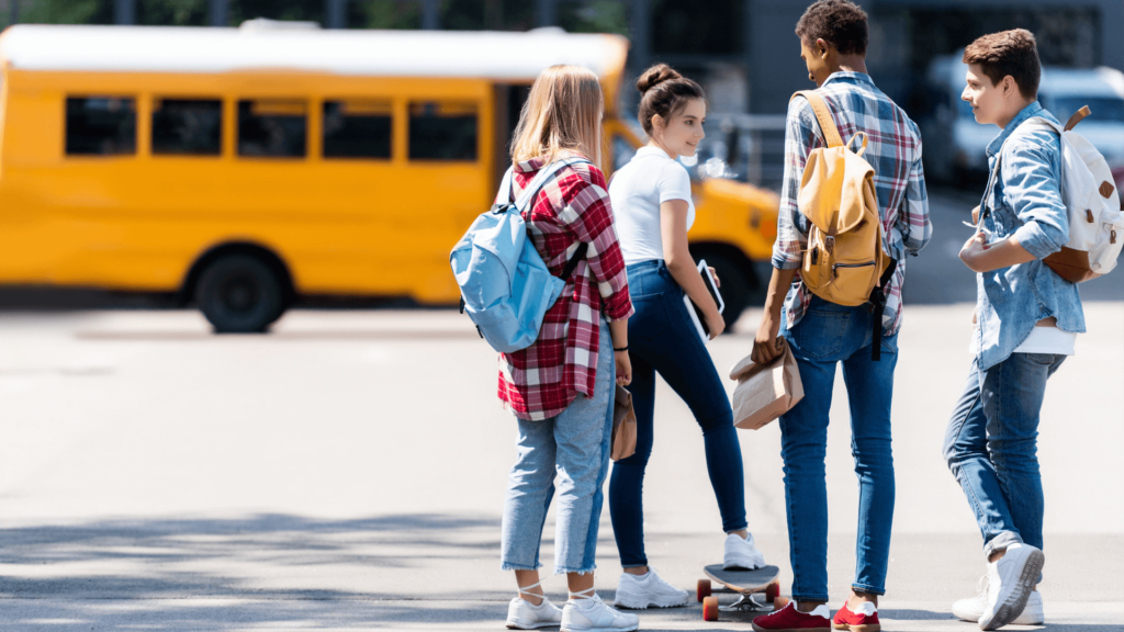 Teens talking outside of school bus